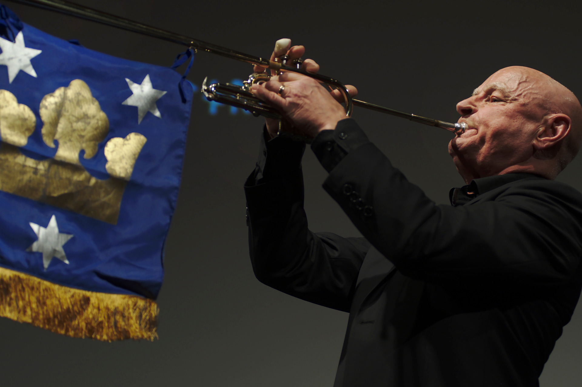 Anders Kästel spelar trumpet framför fanan